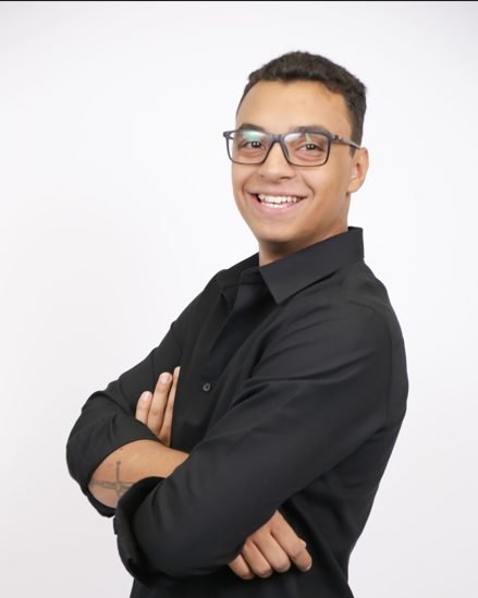 Pedro Gottlob, de camisa preta e braços cruzados, sorrindo
